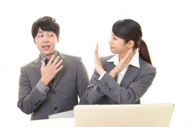 ×マークを作る女性と驚く男性